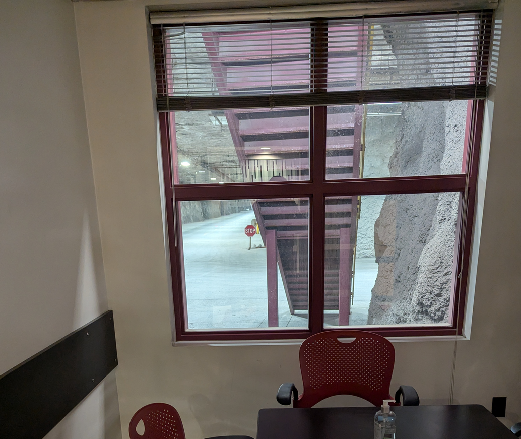 A small lunch room with a window staring out into rock.